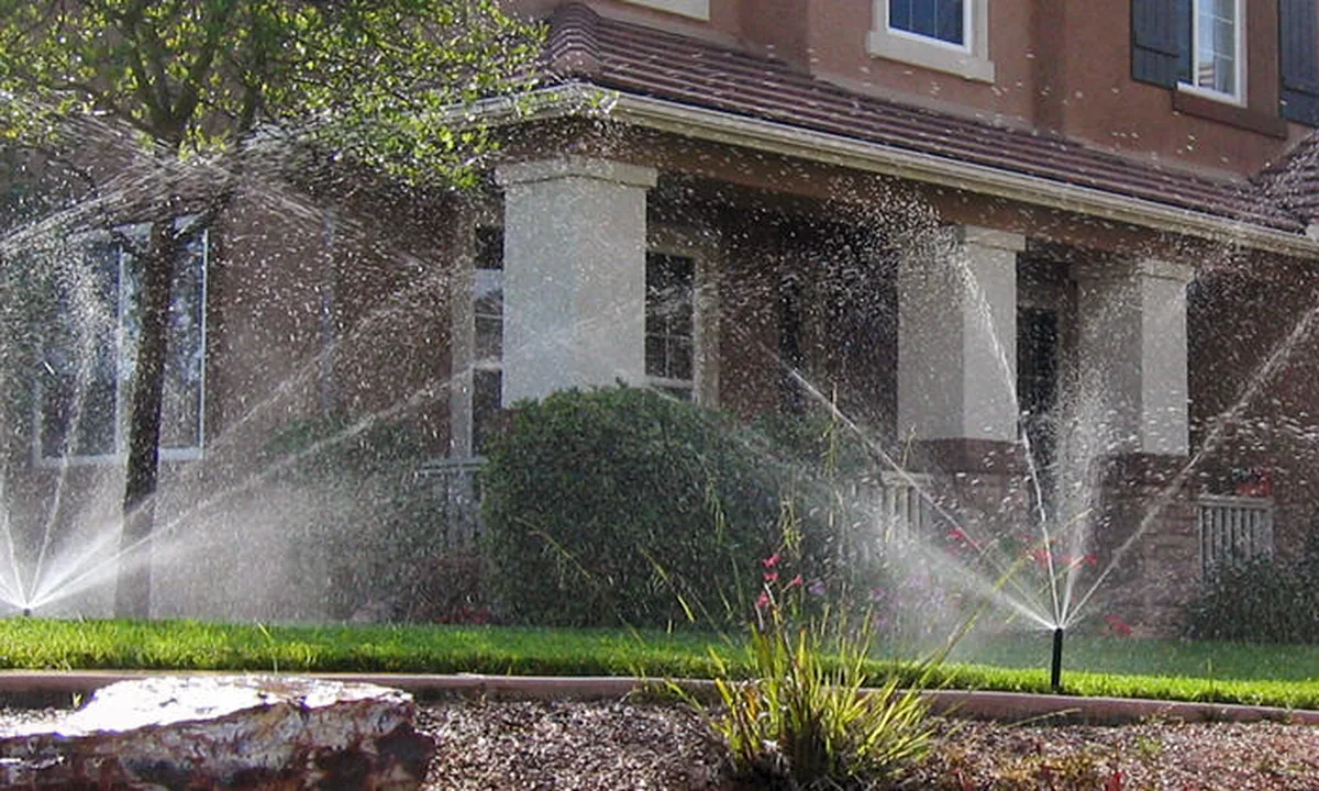 Hunter in-ground sprinklers watering the lawn in front of a residential home