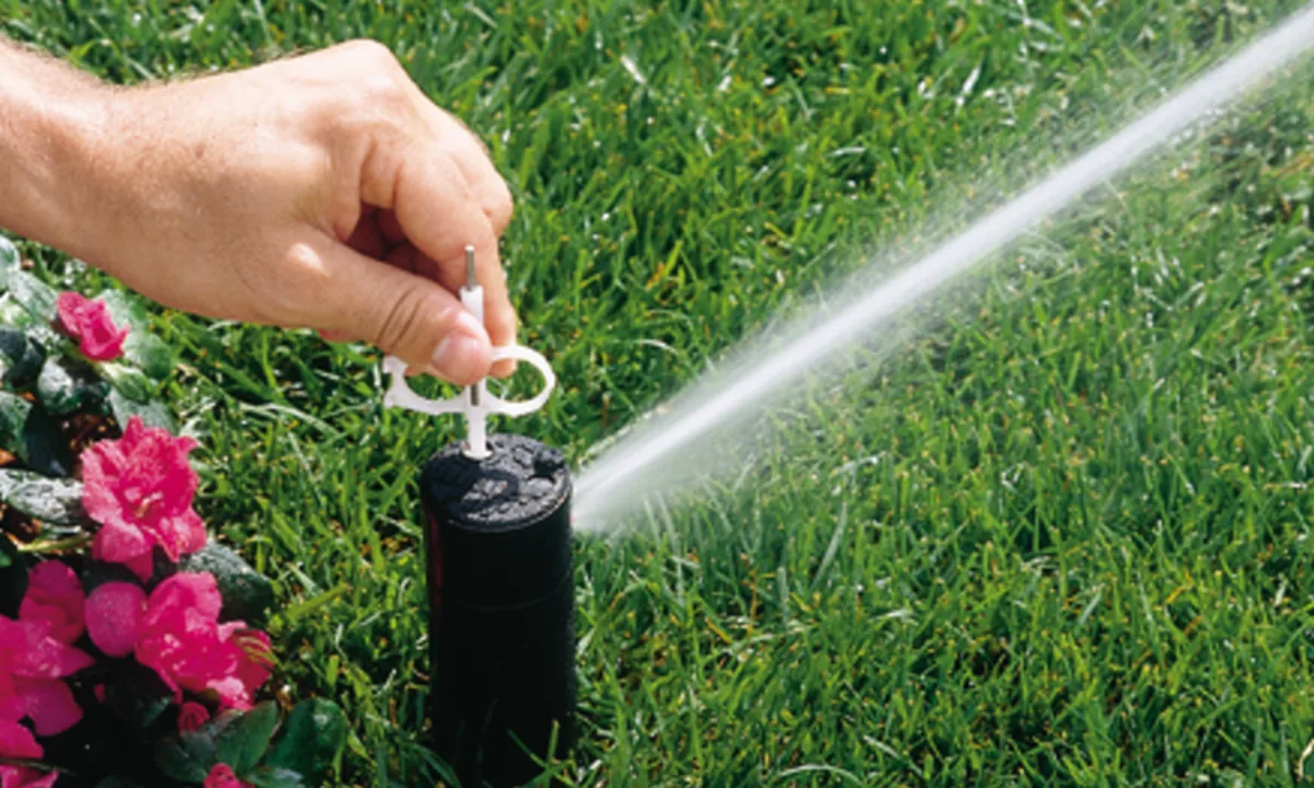 Hand adjusting the arc on a Hunter PGP rotor head while it sprays