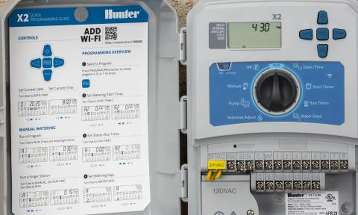 Hunter X2 irrigation controller mounted on a wall with its door open